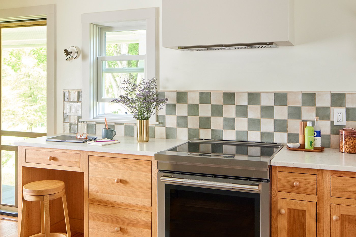A cheerful kitchen with warm woods and green tones that gets lots of light through the Andersen 200 Series Double-Hung Windows.