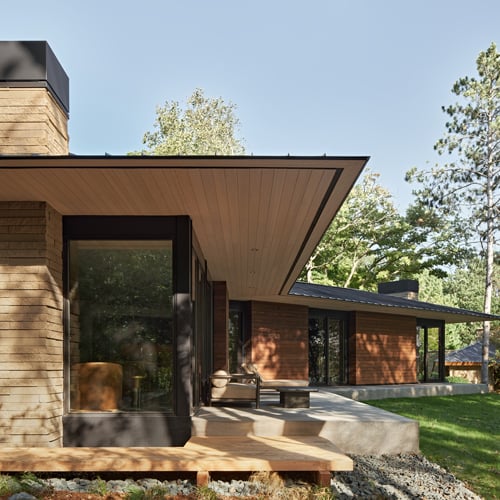 Mid-century modern home with tall windows and unique roofline
